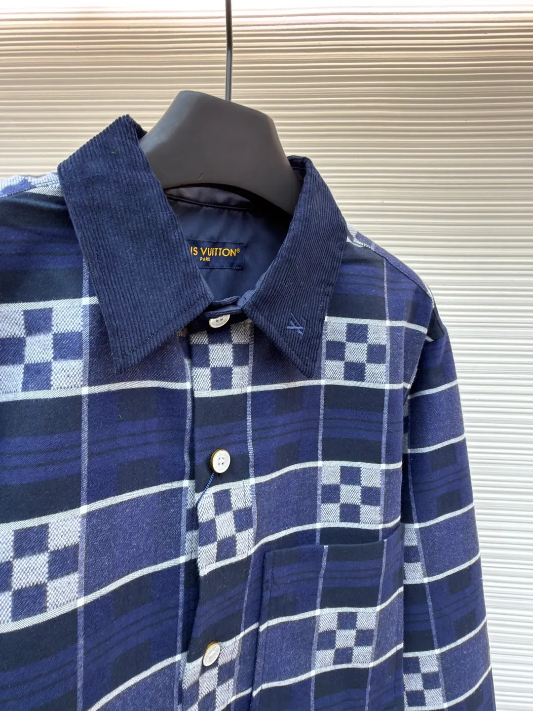 LOUIS VUITTON SKI ski series flannel checkerboard long-sleeved shirt ●Original version: purchased and developed by 14289 ●Item number: 1682075-B50 ●Fabric: flannel fabric ●Technology: printing production ●Color: blue ●Version: fitted version ●Weight: about 725 grams ●Size: S-M-L-XL ●Description: The checkered texture of dark and light navy blue and gray is woven through the yarn-dyed weaving process, in which the brand's classic Damier checkerboard element is embedded. The texture is clear and the color fastness is excellent. The body is spliced ​​with corduroy lapels and cuffs, the velvet strips are fine and full, and the high-temperature shaping process ensures stiffness. The placket uses natural mother-of-pearl buttons, which are hand-polished and polished to give it a warm texture; the leather plaque at the hem is made of first-layer calfskin, which is embossed and hot stamped to present the brand logo, and the edges are hand-oiled to be smooth and burr-free. The overall tailoring is shaped by three-dimensional cutting technology to create a fitted silhouette. The stitching line adopts double-needle overlocking technology, and every inch of stitches is evenly arranged. The embedded shoulder and side seams make the clothes more comfortable to wear. The exquisite clothing craftsmanship and brand ingenuity are fully demonstrated in the details.